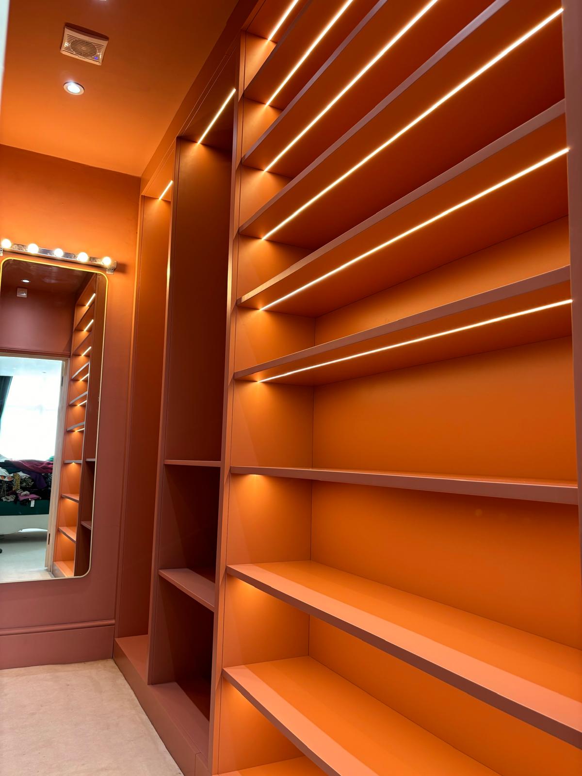 bespoke orange fitted shelving for walk in wardrobe. Bespoke furniture designer and manufacturer in Essex, Danburty.