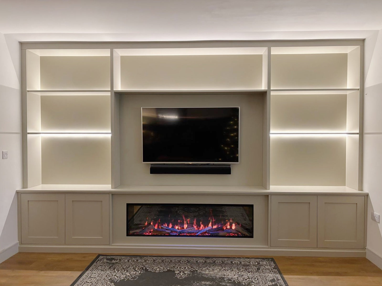 fitted media wall with shelving units with built in electric fire. bespoke fitted furniture marker in essex. built in storage solutions.